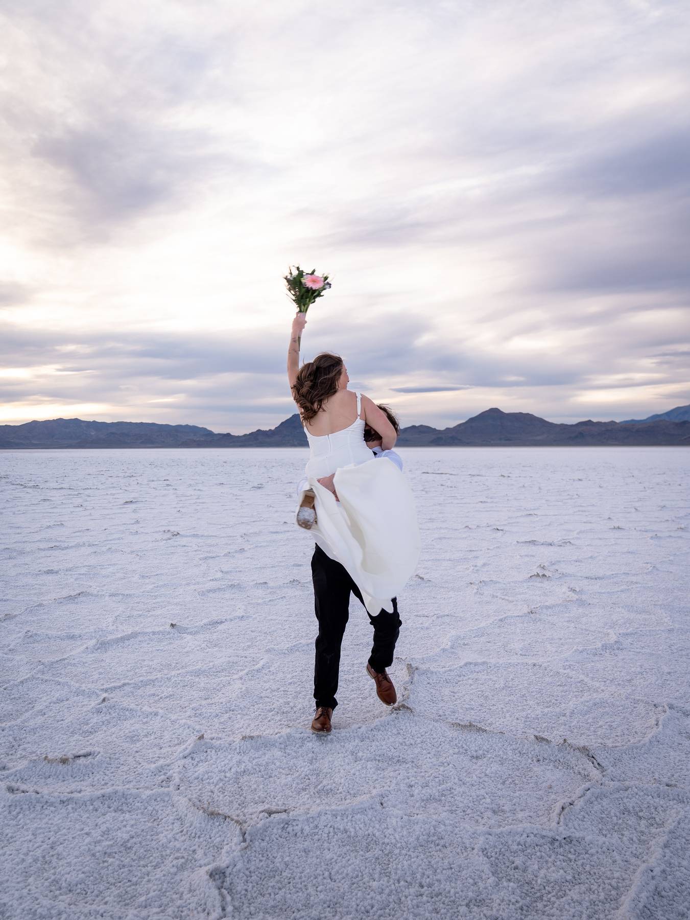 Couple twirling at the Utah Bonneville Salt Flats for Sunset Destination Elopement